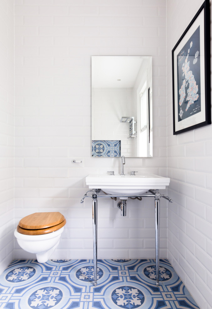 ロンドンにあるトランジショナルスタイルのおしゃれなトイレ・洗面所 (白いタイル、サブウェイタイル、コンソール型シンク、青い床) の写真