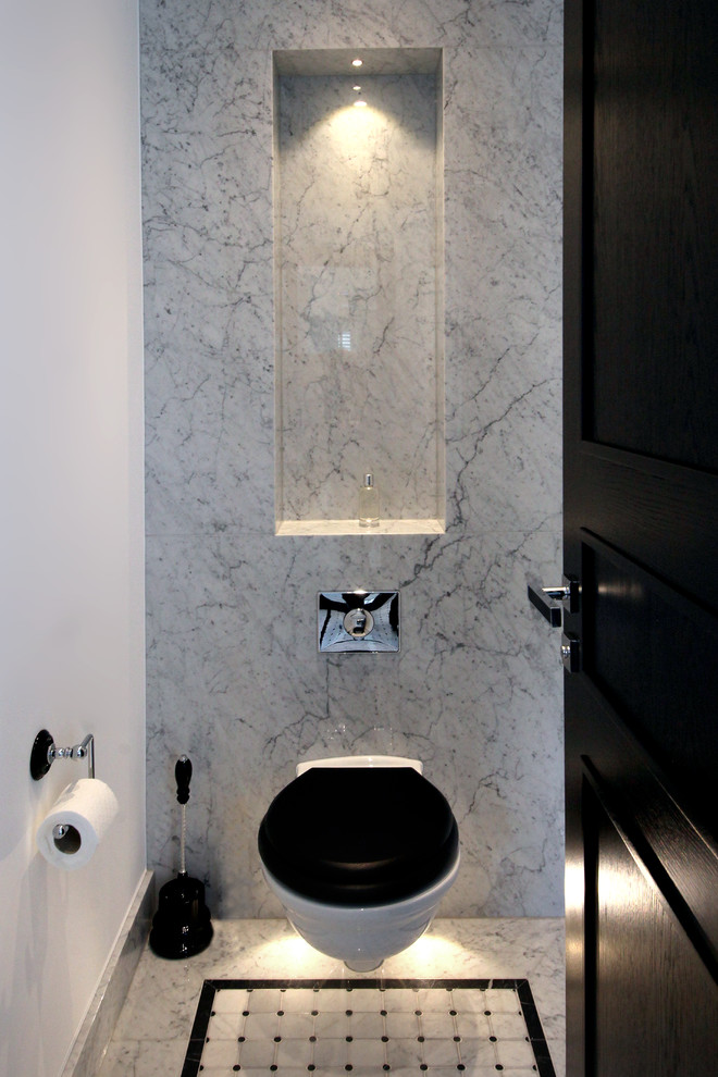 Modern inredning av ett litet toalett, med en vägghängd toalettstol, marmorkakel och marmorgolv