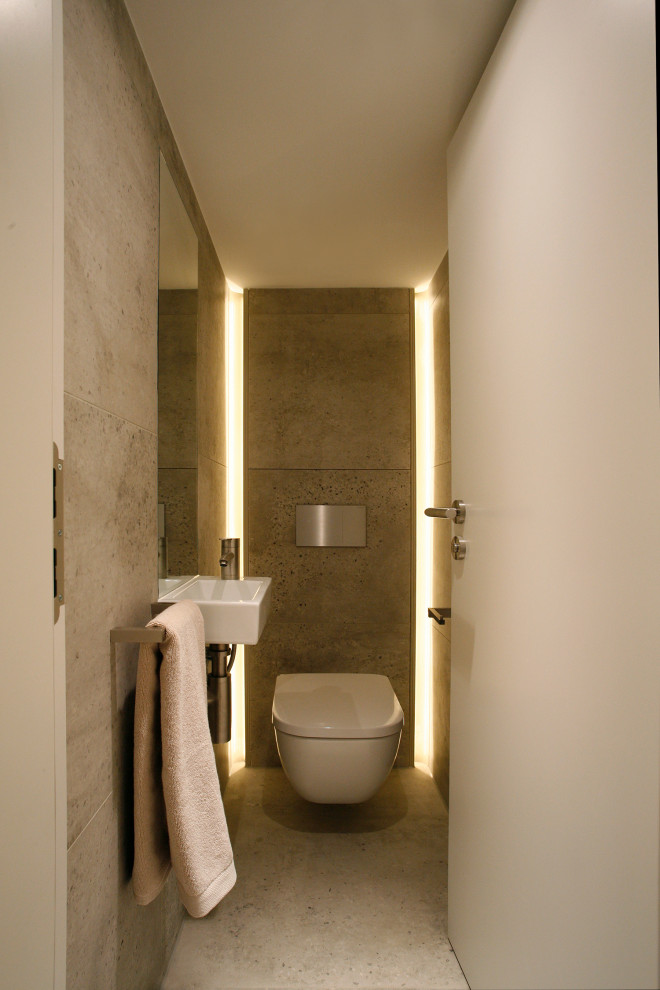サセックスにある小さなコンテンポラリースタイルのおしゃれなトイレ・洗面所 (壁掛け式トイレ、グレーのタイル、セメントタイル、グレーの壁、コンクリートの床、壁付け型シンク、グレーの床) の写真