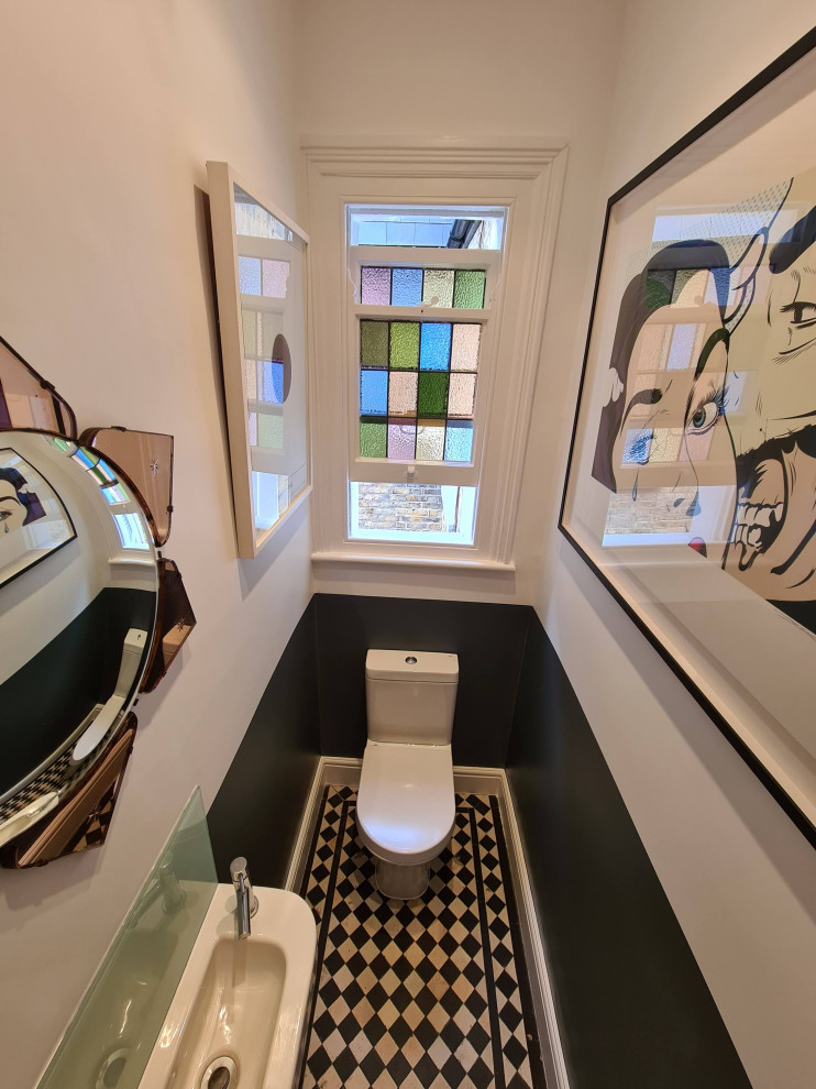 Photo of a medium sized modern cloakroom in London with freestanding cabinets, white cabinets, a two-piece toilet, porcelain tiles, white walls, porcelain flooring, a wall-mounted sink, beige floors, a freestanding vanity unit and a drop ceiling.
