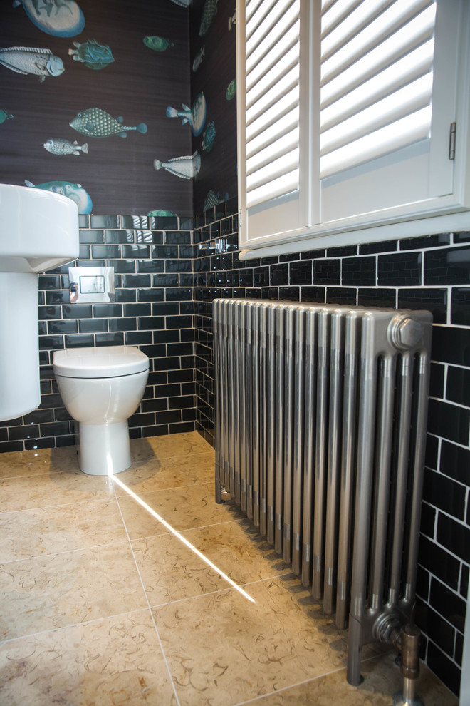 Пример оригинального дизайна: маленький туалет в современном стиле с унитазом-моноблоком, черной плиткой, стеклянной плиткой, черными стенами, полом из известняка, подвесной раковиной и бежевым полом для на участке и в саду