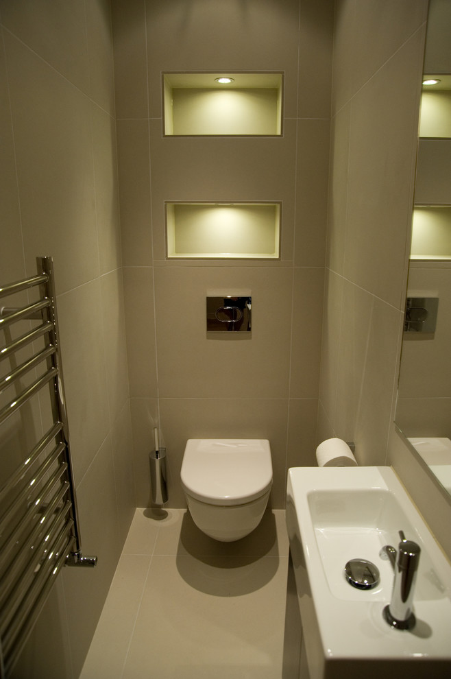 ロンドンにあるラグジュアリーな小さなコンテンポラリースタイルのおしゃれなトイレ・洗面所 (コンソール型シンク、フラットパネル扉のキャビネット、濃色木目調キャビネット、壁掛け式トイレ、ベージュのタイル、磁器タイル、グレーの壁、磁器タイルの床、グレーの床) の写真
