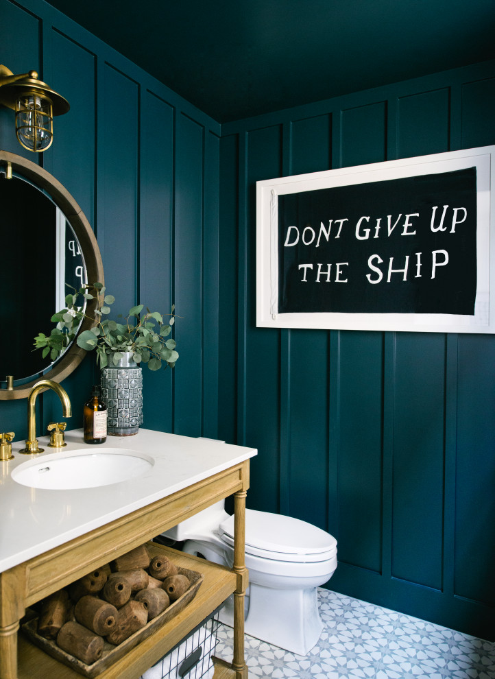 Inspiration för ett vintage vit vitt toalett, med öppna hyllor, skåp i mellenmörkt trä, en toalettstol med separat cisternkåpa, blå väggar, ett undermonterad handfat, bänkskiva i kvarts och flerfärgat golv