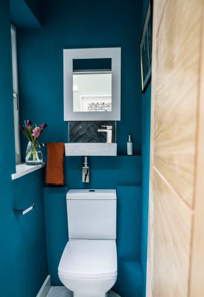 Стильный дизайн: маленький туалет в скандинавском стиле с унитазом-моноблоком, синей плиткой, керамогранитной плиткой, синими стенами, полом из керамогранита, подвесной раковиной и белым полом для на участке и в саду - последний тренд