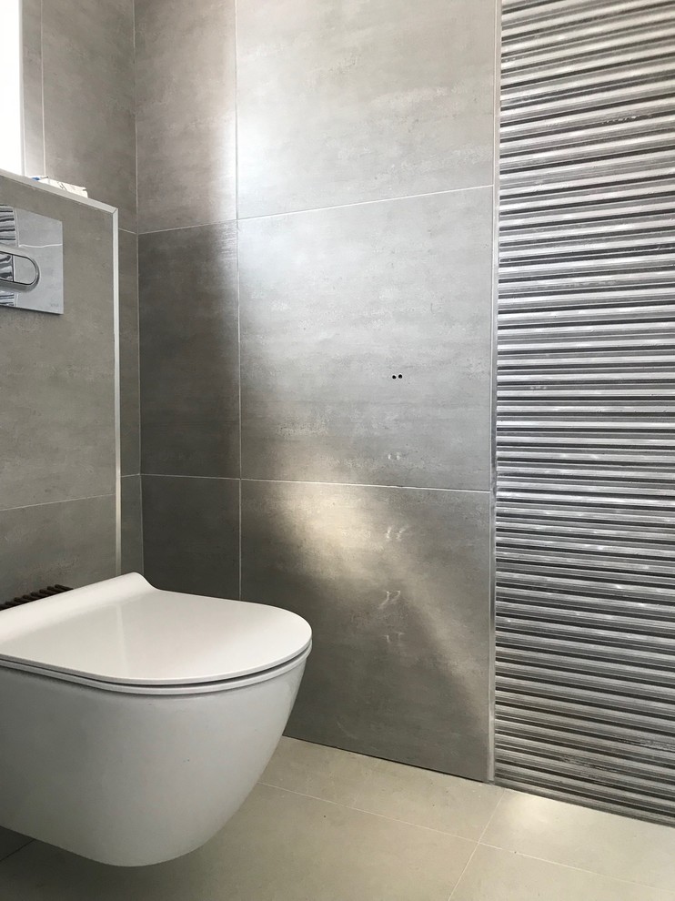 Design ideas for a large urban cloakroom in London with flat-panel cabinets, dark wood cabinets, a wall mounted toilet, grey tiles, porcelain tiles, grey walls, porcelain flooring, a wall-mounted sink, solid surface worktops, grey floors and white worktops.