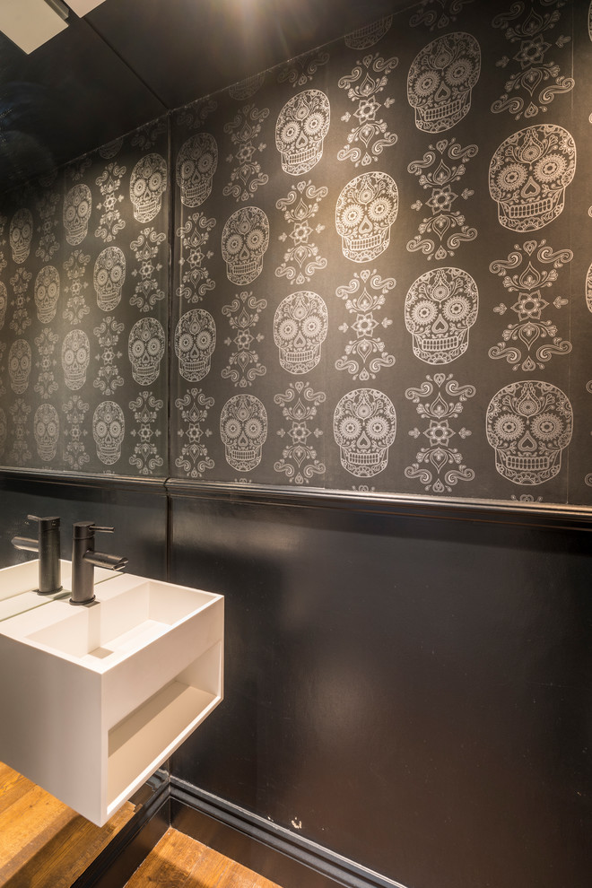 Kleine Stilmix Gästetoilette mit schwarzer Wandfarbe, hellem Holzboden und Wandwaschbecken in London