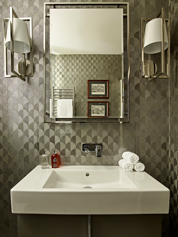 Inspiration for a contemporary cloakroom in London with flat-panel cabinets, grey cabinets, a wall mounted toilet, cement tiles, grey walls, porcelain flooring, an integrated sink and grey floors.