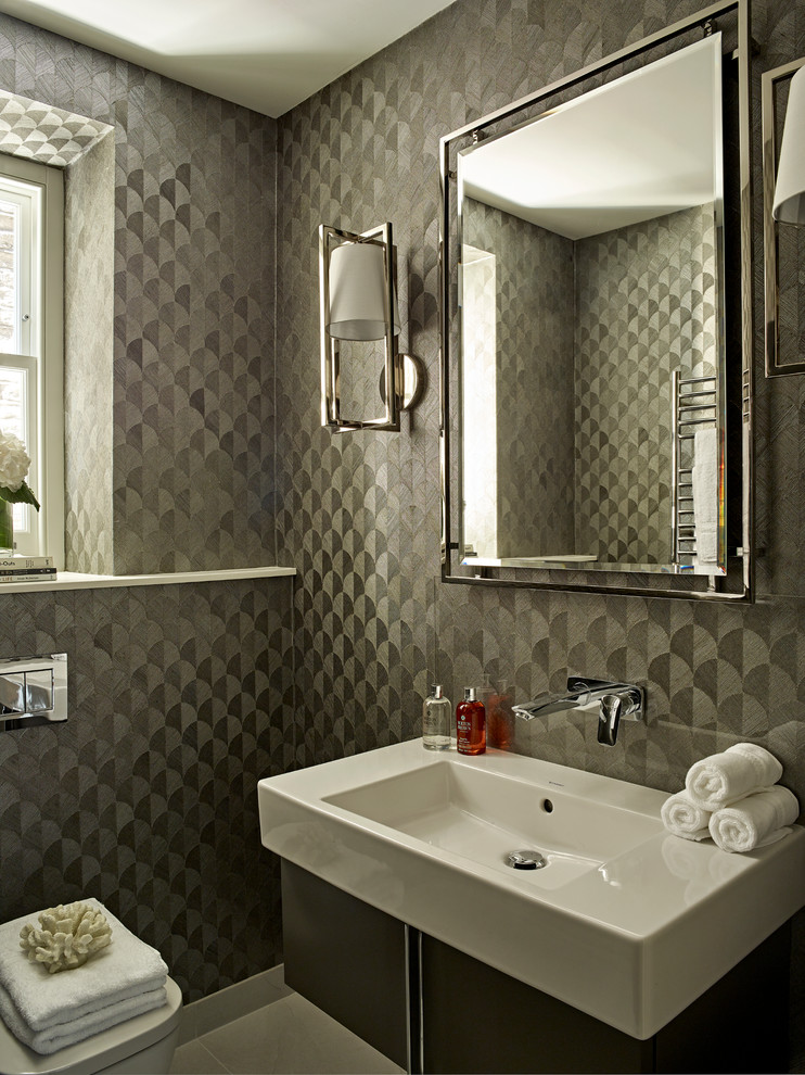 Kleine Moderne Gästetoilette mit flächenbündigen Schrankfronten, grauen Schränken, Wandtoilette, grauer Wandfarbe, Porzellan-Bodenfliesen, grauem Boden und Waschtischkonsole in London