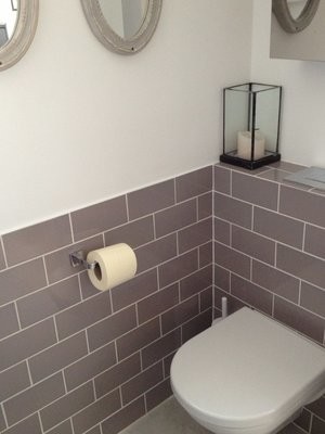 Esempio di un piccolo bagno di servizio minimalista con ante in stile shaker, ante bianche, WC sospeso, piastrelle grigie, piastrelle in ceramica, pareti grigie, pavimento con piastrelle in ceramica, lavabo sospeso e pavimento bianco