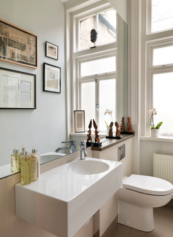 Foto de aseo contemporáneo pequeño con lavabo suspendido, encimera de mármol, sanitario de una pieza, baldosas y/o azulejos beige, paredes grises y suelo de baldosas de porcelana