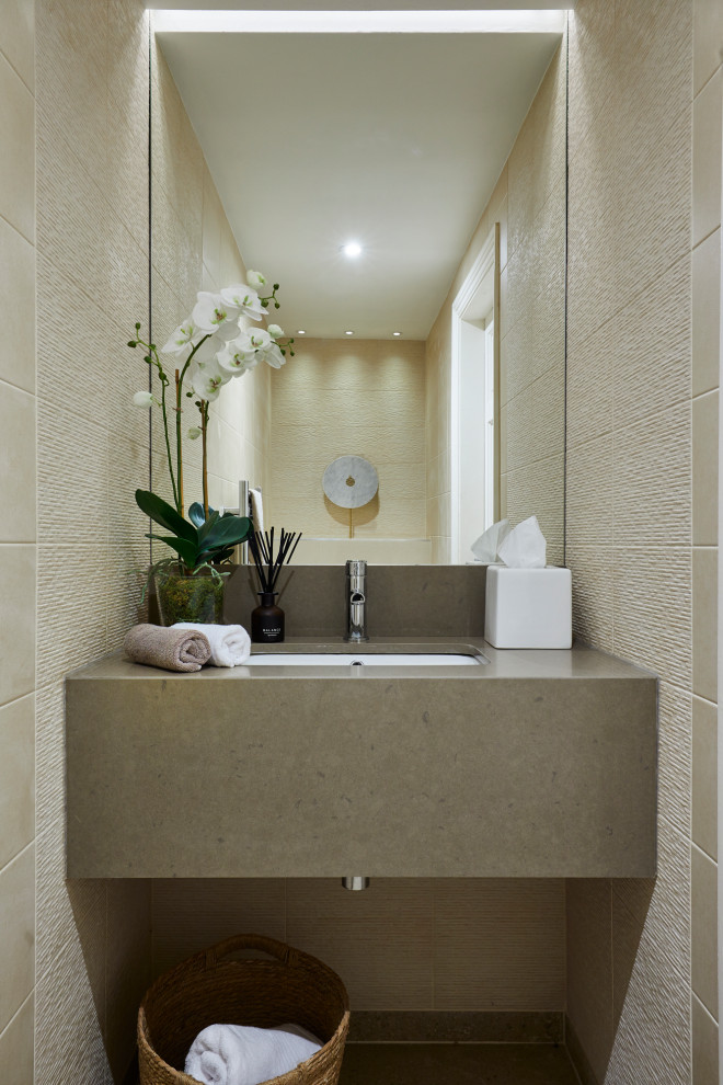 Idée de décoration pour un petit WC et toilettes design avec des portes de placard beiges, un carrelage beige, des carreaux de porcelaine, un mur beige, un sol en carrelage de céramique, un plan de toilette en quartz, un sol beige, un plan de toilette beige, meuble-lavabo suspendu et un lavabo encastré.