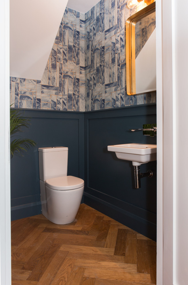 他の地域にある小さなコンテンポラリースタイルのおしゃれなトイレ・洗面所 (青い壁、無垢フローリング、ベージュの床) の写真