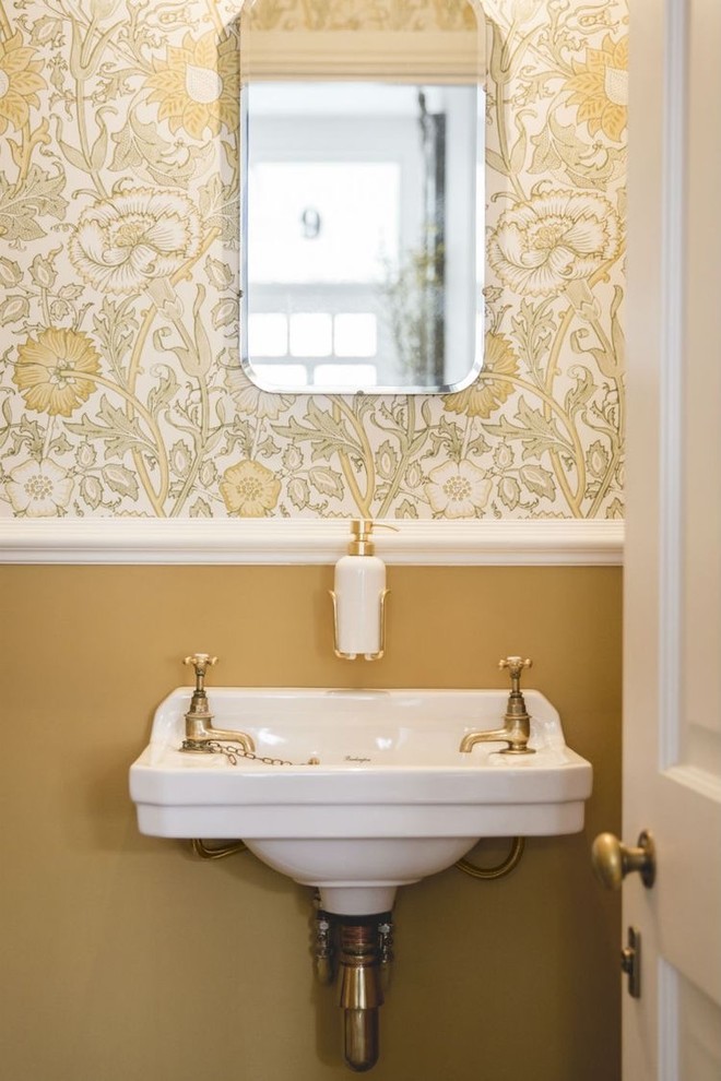 ロンドンにあるトラディショナルスタイルのおしゃれなトイレ・洗面所 (マルチカラーの壁、壁付け型シンク) の写真