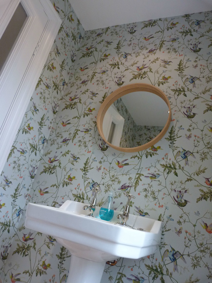 Esempio di un bagno di servizio design con lavabo a colonna e pavimento in legno massello medio