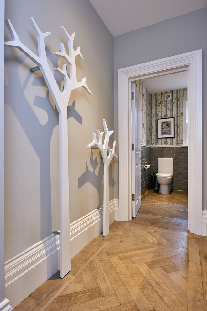 Große Stilmix Gästetoilette mit Toilette mit Aufsatzspülkasten, grauen Fliesen, Metrofliesen, grauer Wandfarbe und braunem Holzboden in London
