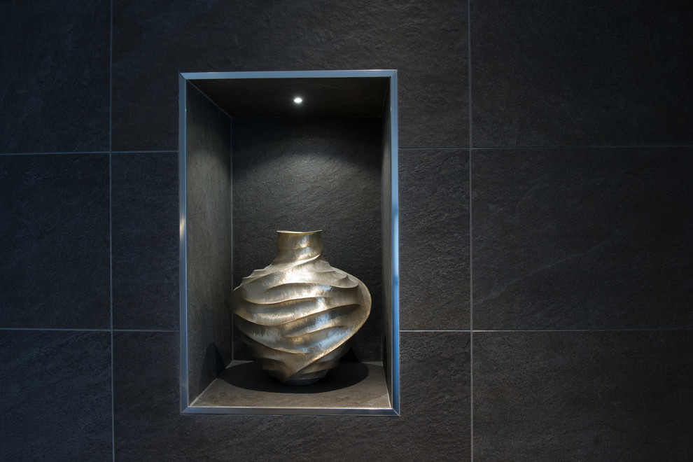 Idée de décoration pour un WC et toilettes minimaliste avec un carrelage noir, des carreaux de porcelaine, un mur noir, un sol en carrelage de porcelaine et un sol noir.