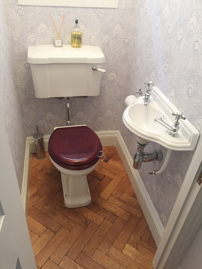 This is an example of a small classic cloakroom in London with a two-piece toilet, multi-coloured walls and a wall-mounted sink.