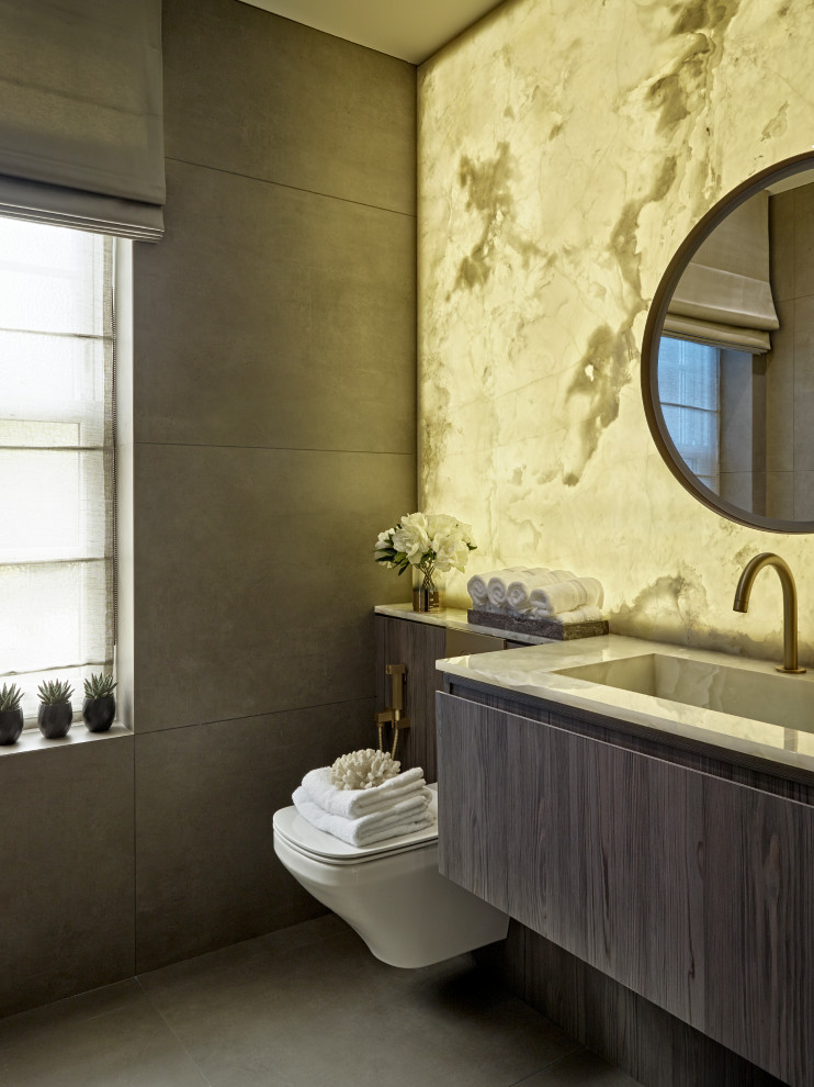 Стильный дизайн: туалет в современном стиле с плоскими фасадами, серыми фасадами, инсталляцией, серой плиткой, серыми стенами, монолитной раковиной, серым полом, белой столешницей и подвесной тумбой - последний тренд