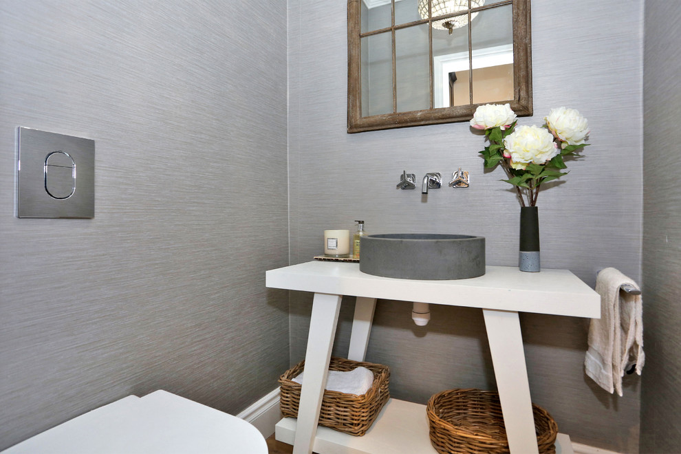 Inspiration pour un petit WC et toilettes design avec un mur gris, une vasque et un plan de toilette blanc.