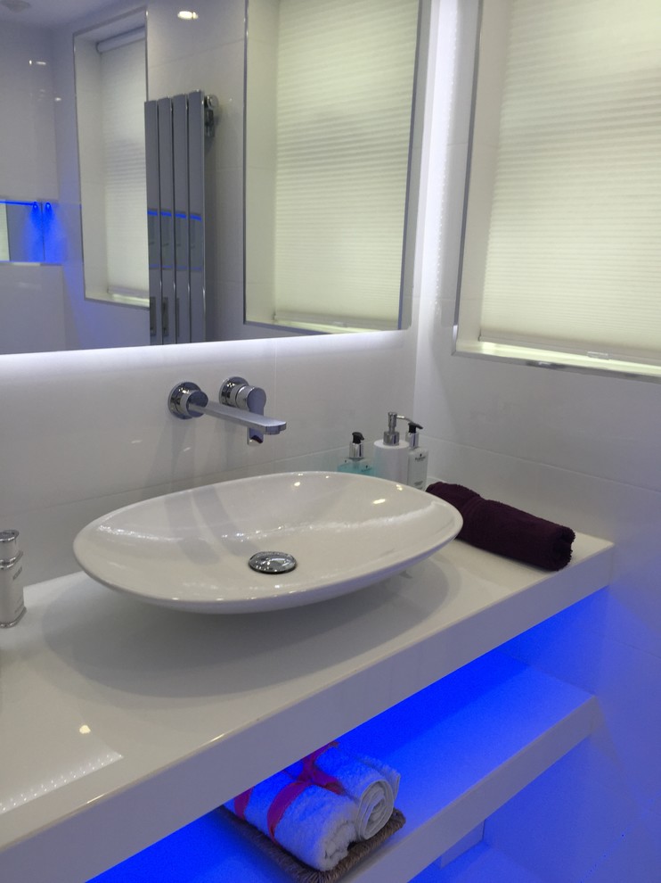This is an example of a medium sized contemporary cloakroom in London with a pedestal sink, quartz worktops, white tiles, ceramic tiles and white walls.