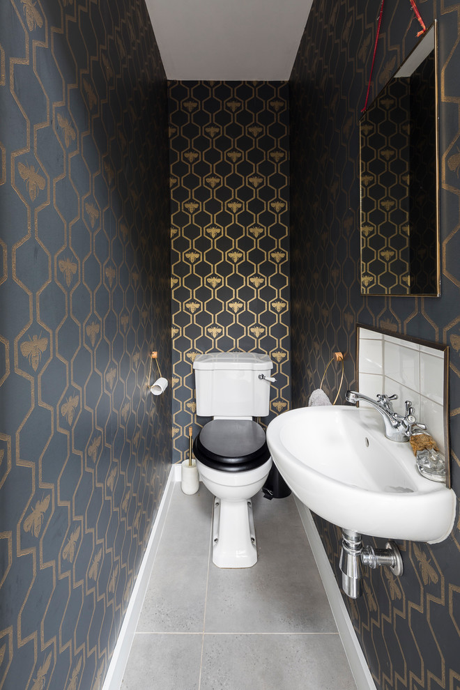 ロンドンにあるラグジュアリーな小さなトラディショナルスタイルのおしゃれなトイレ・洗面所 (分離型トイレ、白いタイル、セラミックタイル、青い壁、セラミックタイルの床、壁付け型シンク、グレーの床) の写真