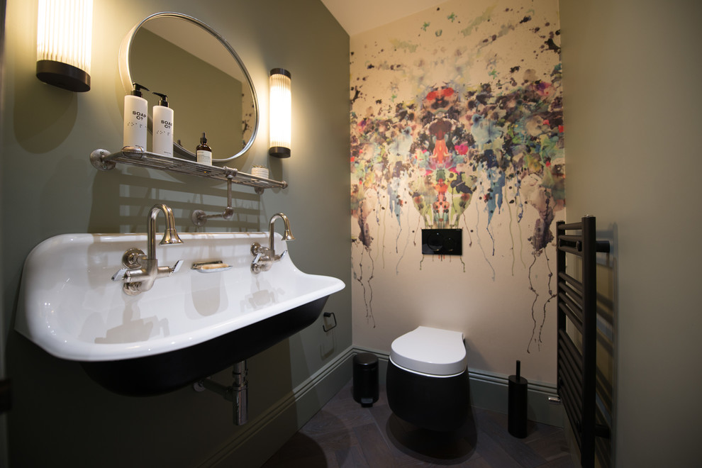 Idée de décoration pour un petit WC suspendu tradition avec un mur vert, parquet foncé, un lavabo suspendu et un sol marron.