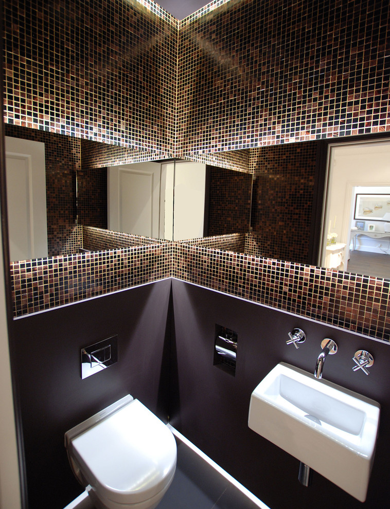 Inspiration for a small contemporary cloakroom in London with a wall mounted toilet, brown tiles, brown walls, marble flooring, a wall-mounted sink and mosaic tiles.