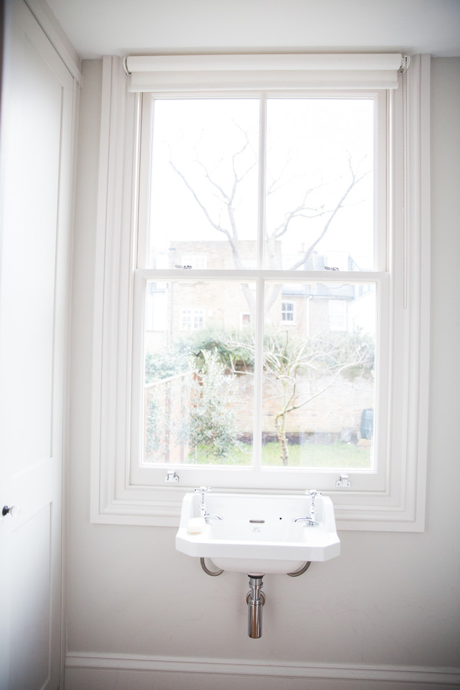 Immagine di un piccolo bagno di servizio classico con ante in stile shaker, ante bianche, pareti grigie e lavabo sospeso