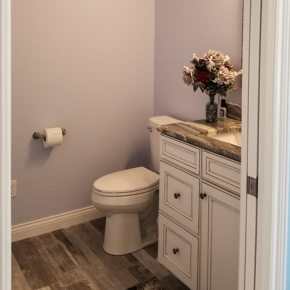 Small traditional cloakroom in Cleveland with recessed-panel cabinets, beige cabinets, a one-piece toilet, grey walls, light hardwood flooring, granite worktops, grey floors, brown worktops and a built in vanity unit.
