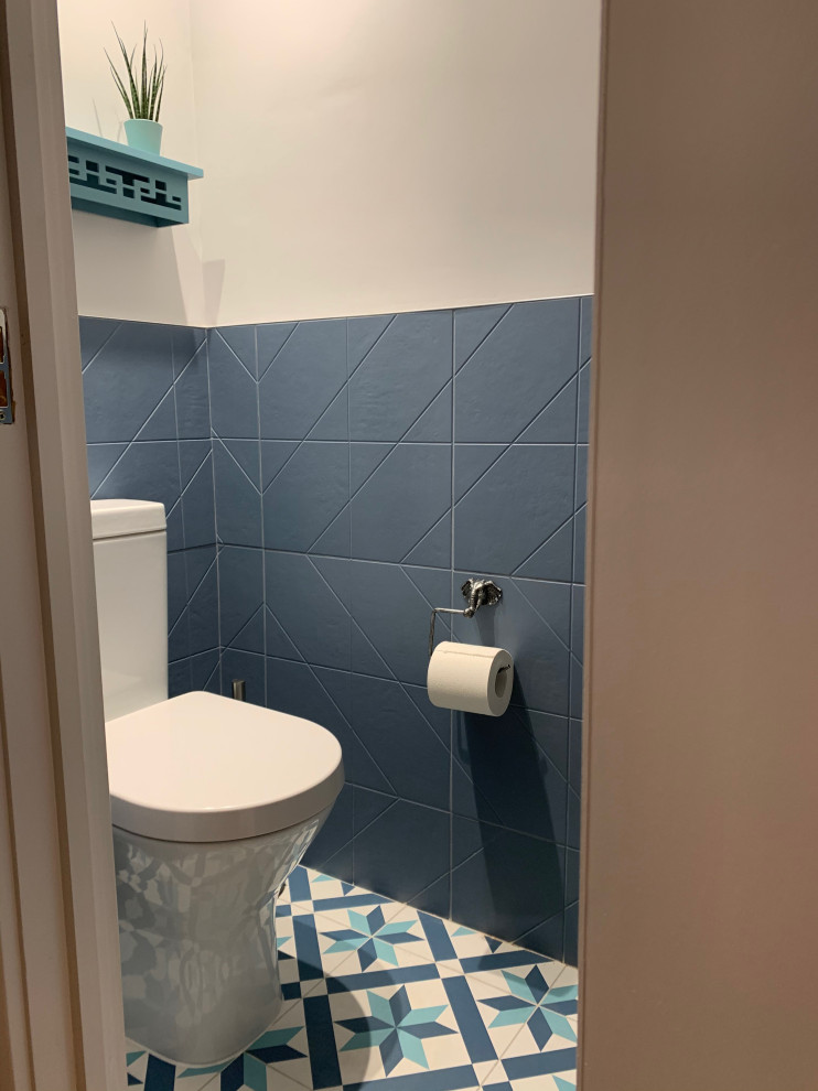 Inspiration för små moderna toaletter, med en toalettstol med hel cisternkåpa, blå kakel, grå väggar, klinkergolv i keramik, ett väggmonterat handfat och flerfärgat golv