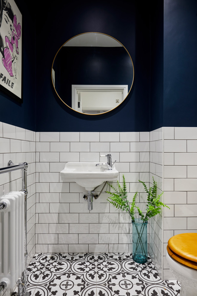 Свежая идея для дизайна: маленький туалет в современном стиле с унитазом-моноблоком, белой плиткой, керамической плиткой, синими стенами, полом из керамической плитки, подвесной раковиной и разноцветным полом для на участке и в саду - отличное фото интерьера