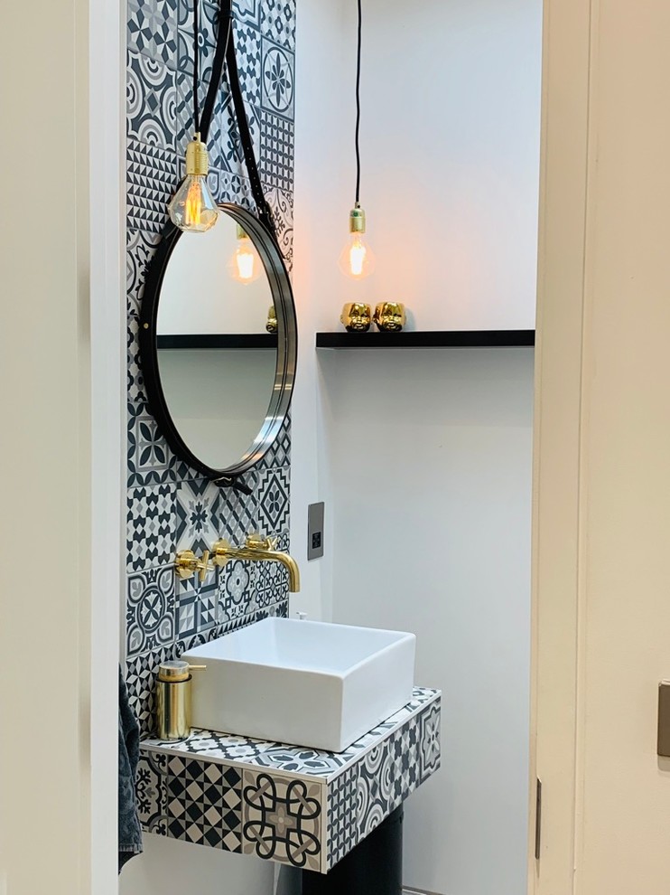Photo of a small industrial cloakroom in London with white tiles, cement tiles, concrete flooring, a wall-mounted sink, tiled worktops, grey floors and multi-coloured worktops.