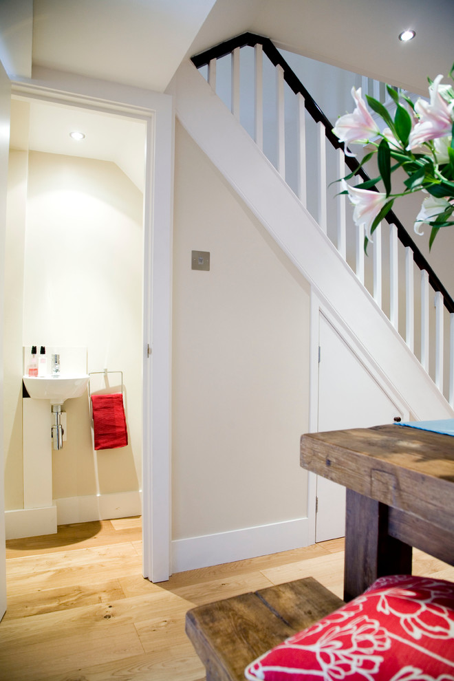 Small modern cloakroom in London with a one-piece toilet, white walls and a wall-mounted sink.