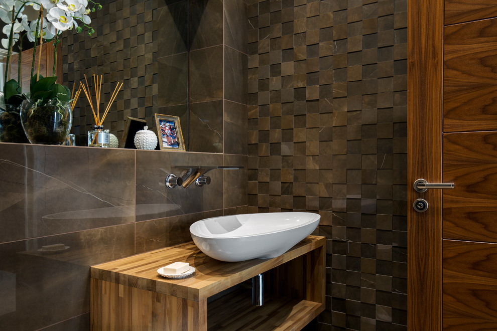 Example of a mid-sized transitional brown tile brown floor powder room design in Surrey with brown walls and a vessel sink