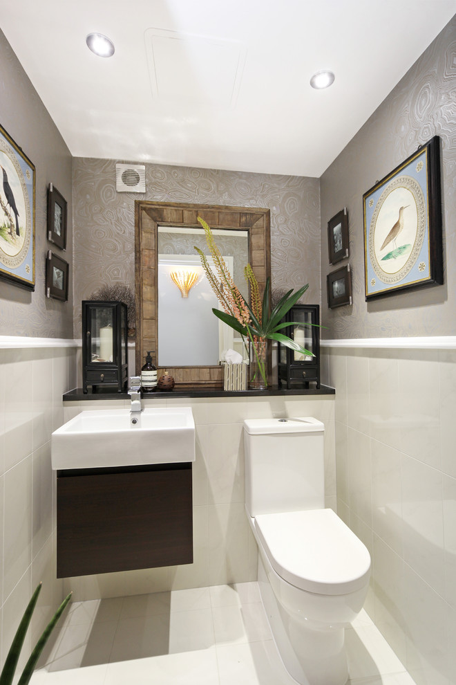 Immagine di un piccolo bagno di servizio contemporaneo con ante lisce, ante nere, WC monopezzo, pareti grigie, lavabo sospeso e pavimento bianco