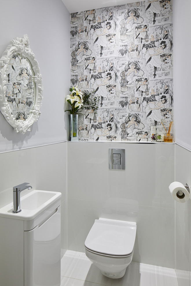 Idée de décoration pour un petit WC suspendu design avec un placard à porte plane, des portes de placard blanches, un carrelage gris, des carreaux de porcelaine, un mur gris, un sol en carrelage de porcelaine, un lavabo intégré, un sol gris et un plan de toilette blanc.