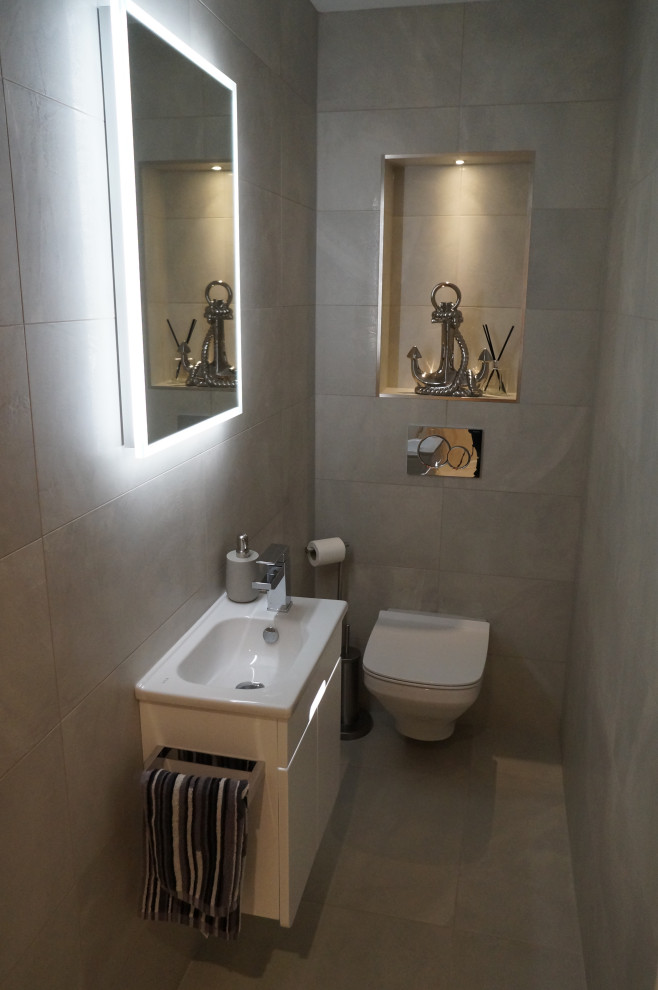 Design ideas for a modern ensuite bathroom in Buckinghamshire with a wall mounted toilet, grey tiles, a built-in sink, grey floors and a single sink.