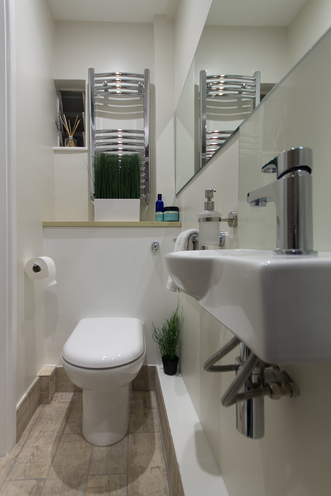 Foto di un piccolo bagno di servizio design con WC monopezzo, piastrelle bianche, pareti beige, lavabo sospeso e top in quarzite