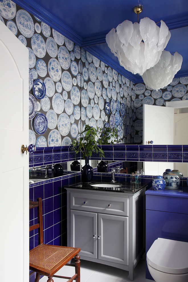 Пример оригинального дизайна: маленький туалет в стиле фьюжн с серыми фасадами, врезной раковиной, инсталляцией, синей плиткой, керамической плиткой, синими стенами, белым полом и фасадами с утопленной филенкой для на участке и в саду
