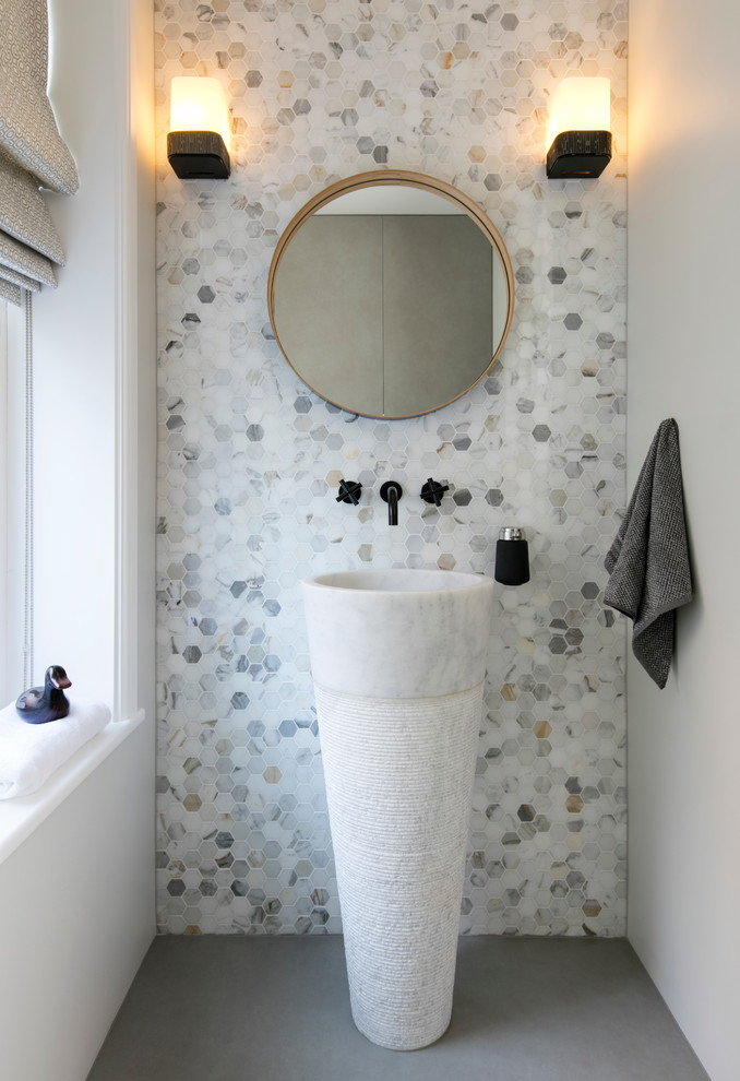 На фото: туалет в современном стиле с серыми стенами, раковиной с пьедесталом, серым полом и акцентной стеной с