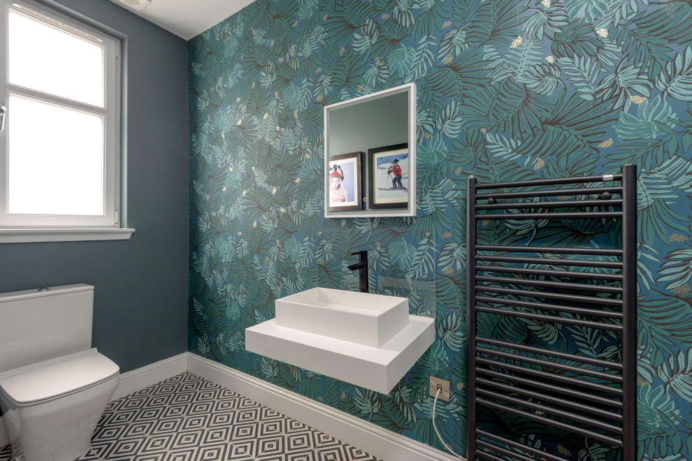 Photo of a large contemporary cloakroom in Other with a one-piece toilet, green walls, a vessel sink, multi-coloured floors, white worktops, a built in vanity unit and wallpapered walls.