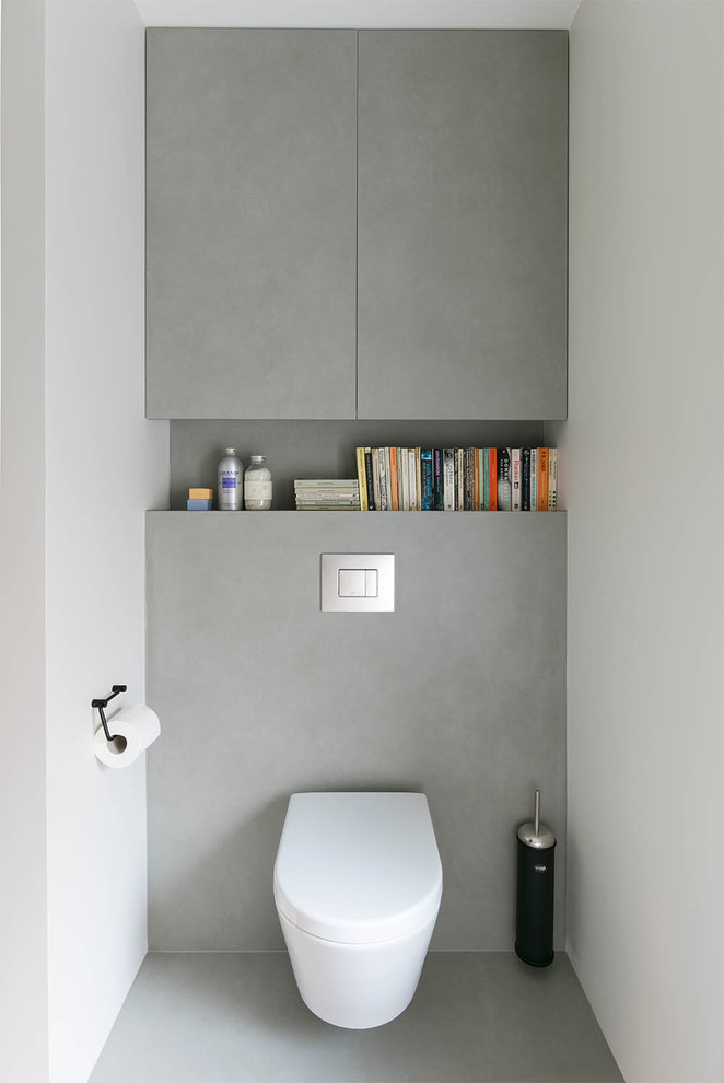 Cette image montre un petit WC suspendu design avec un lavabo de ferme, un carrelage gris et un sol gris.