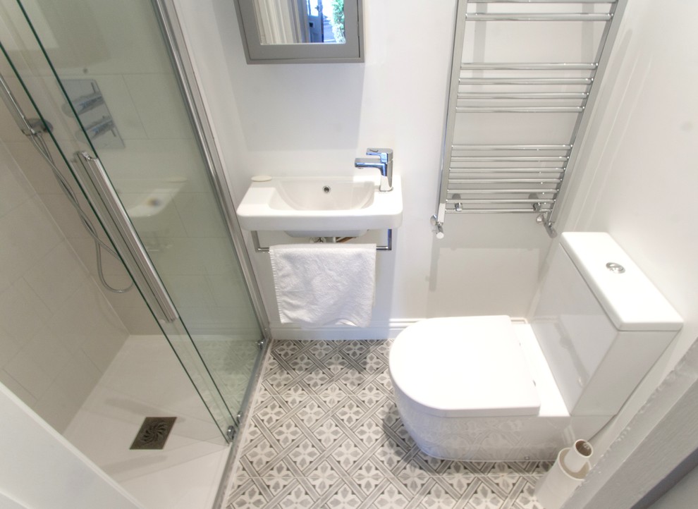 Idéer för att renovera ett litet funkis toalett, med möbel-liknande, vita skåp, en toalettstol med separat cisternkåpa, vit kakel, porslinskakel, vita väggar, klinkergolv i porslin, ett väggmonterat handfat och flerfärgat golv