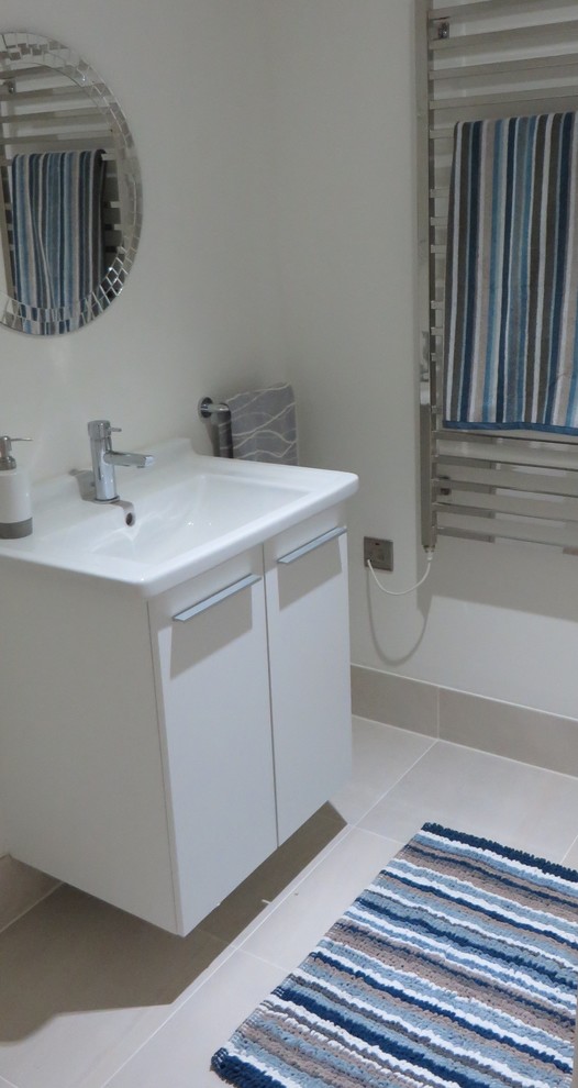 Exemple d'un WC et toilettes bord de mer de taille moyenne avec un carrelage beige, des carreaux de céramique, un mur blanc et un sol en carrelage de céramique.
