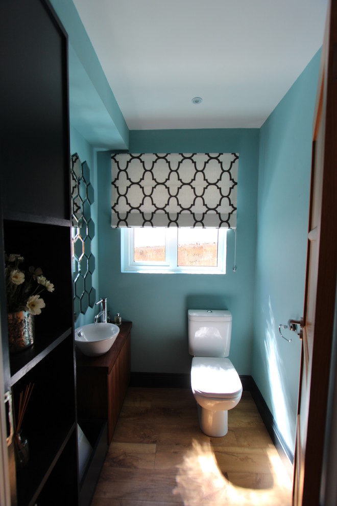 Imagen de aseo moderno con lavabo con pedestal, sanitario de una pieza y paredes azules