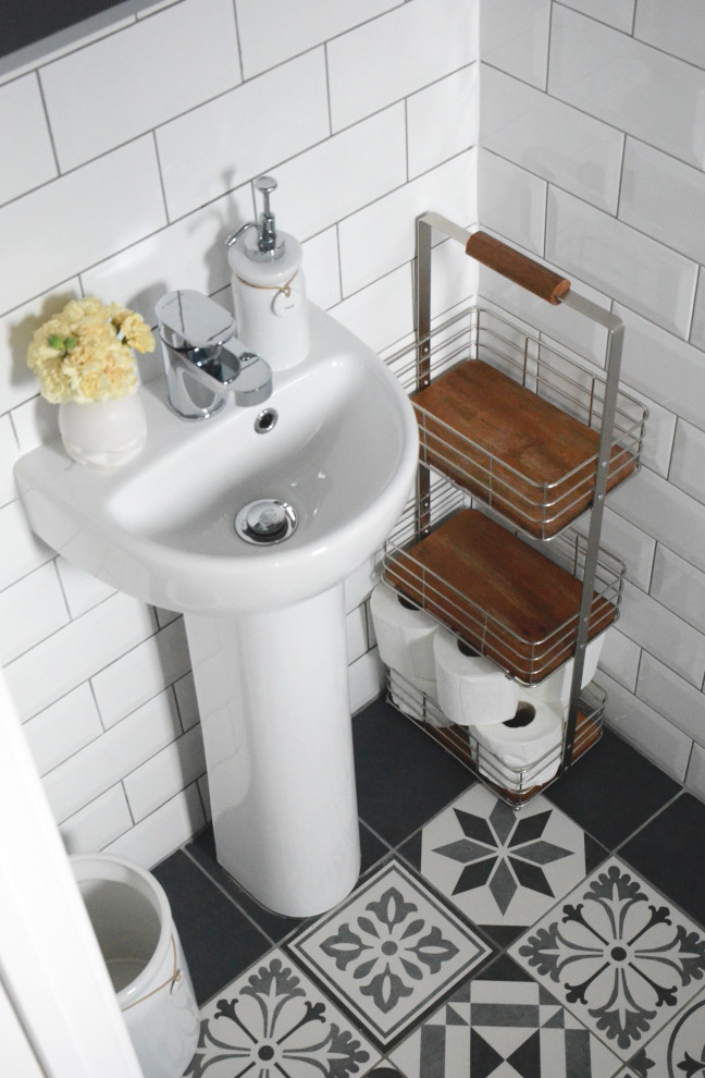 Идея дизайна: маленький туалет в классическом стиле с унитазом-моноблоком, белой плиткой, керамической плиткой, серыми стенами, полом из керамической плитки, разноцветным полом и напольной тумбой для на участке и в саду