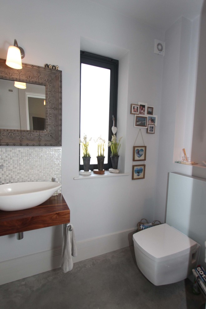 Foto di un bagno di servizio minimalista con lavabo sospeso, top in legno, WC sospeso, piastrelle bianche, pareti bianche e pavimento in cemento