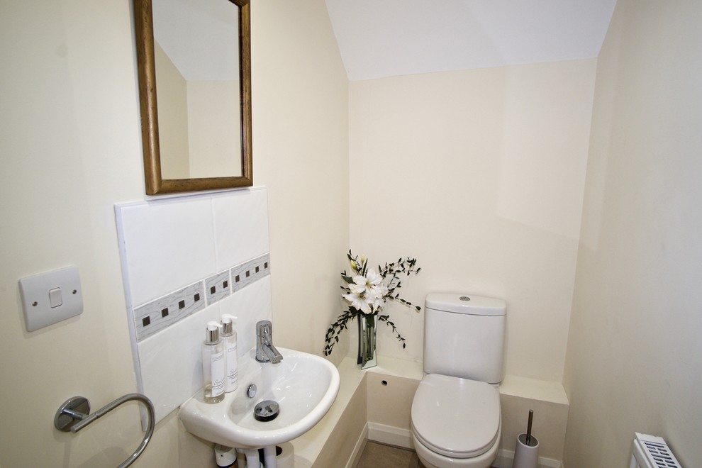 Inspiration for a small classic cloakroom in Surrey with a one-piece toilet, white tiles, ceramic tiles, beige walls, ceramic flooring and a wall-mounted sink.