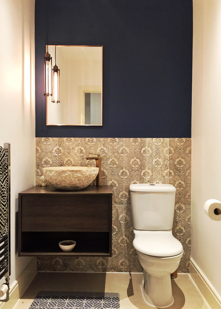 Kleine Mediterrane Gästetoilette mit flächenbündigen Schrankfronten, dunklen Holzschränken, Toilette mit Aufsatzspülkasten, blauer Wandfarbe und brauner Waschtischplatte in Sonstige