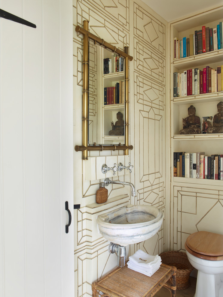 This is an example of a country cloakroom in London with a wall-mounted sink, open cabinets and a two-piece toilet.